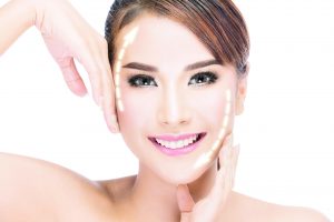 51111477 - beauty, plastic surgery, aging, people and health concept - beautiful young woman touching her face with lifting arrows isolated on white with clipping path