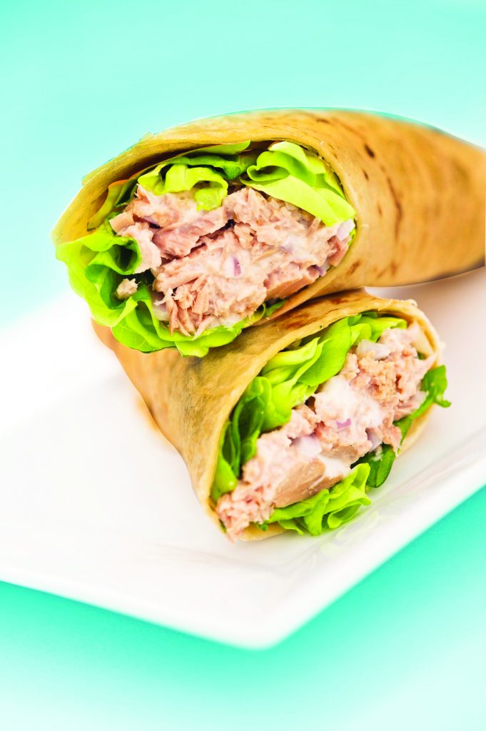 11052792 - two tuna melt wrap on a white plate on a blue background