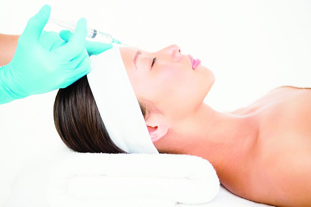 42398744 - woman receiving botox injection on her forehead in medical office