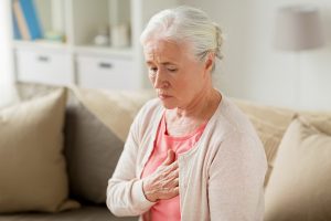 old age, health problem and people concept - senior woman suffering from heartache at home