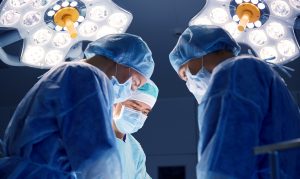 surgery, medicine and people concept - group of surgeons at operation in operating room at hospital